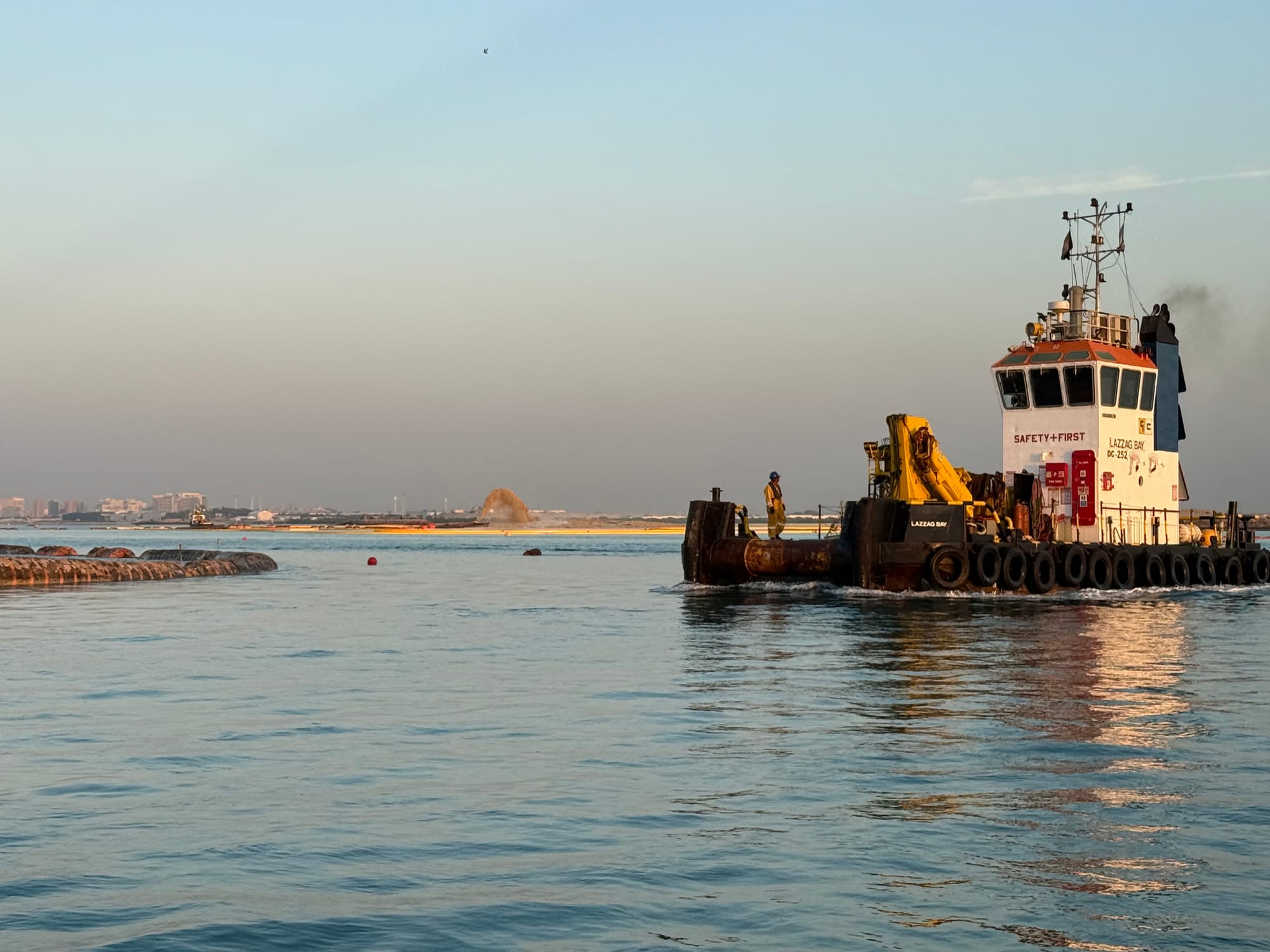 Blue tug Shark Bay viewed from the bow quarter, tyre fenders along its hull.