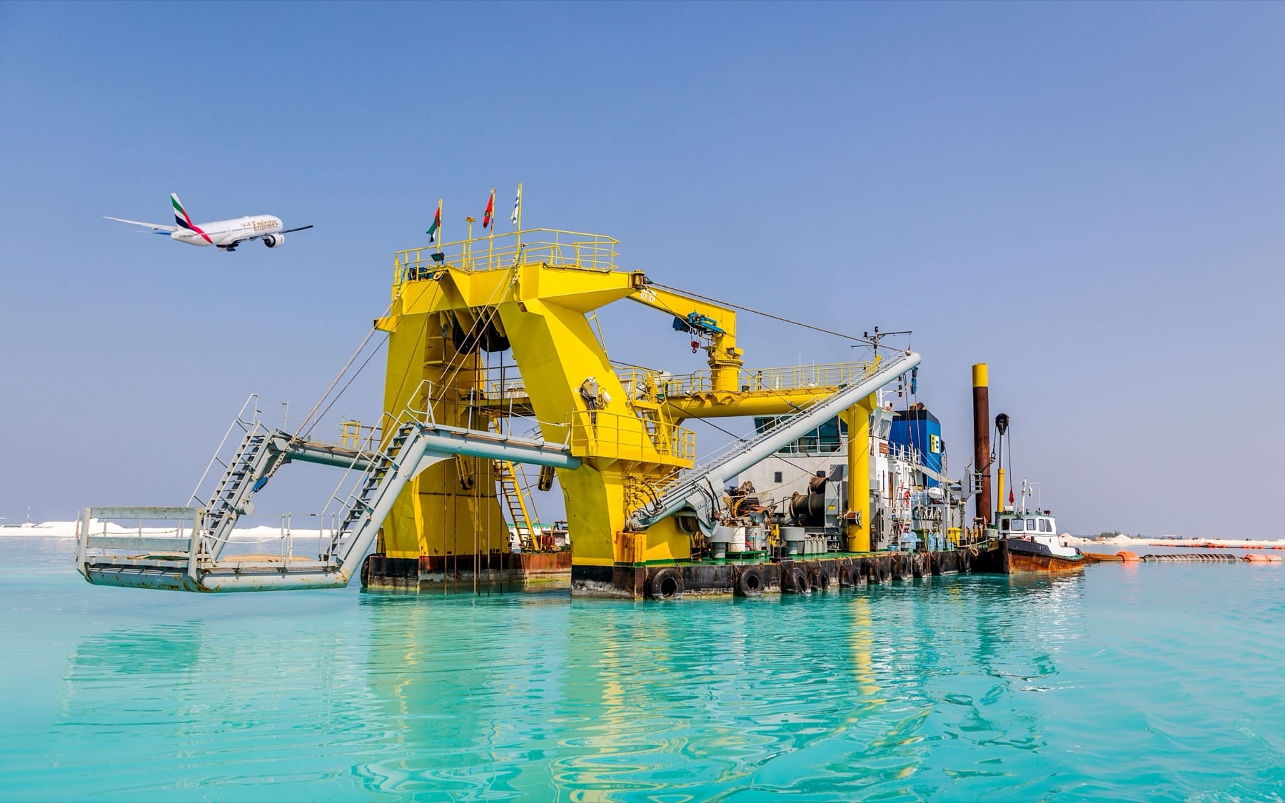 The Khaleej Bay dredging with an Emirates aircraft on the apron behind.