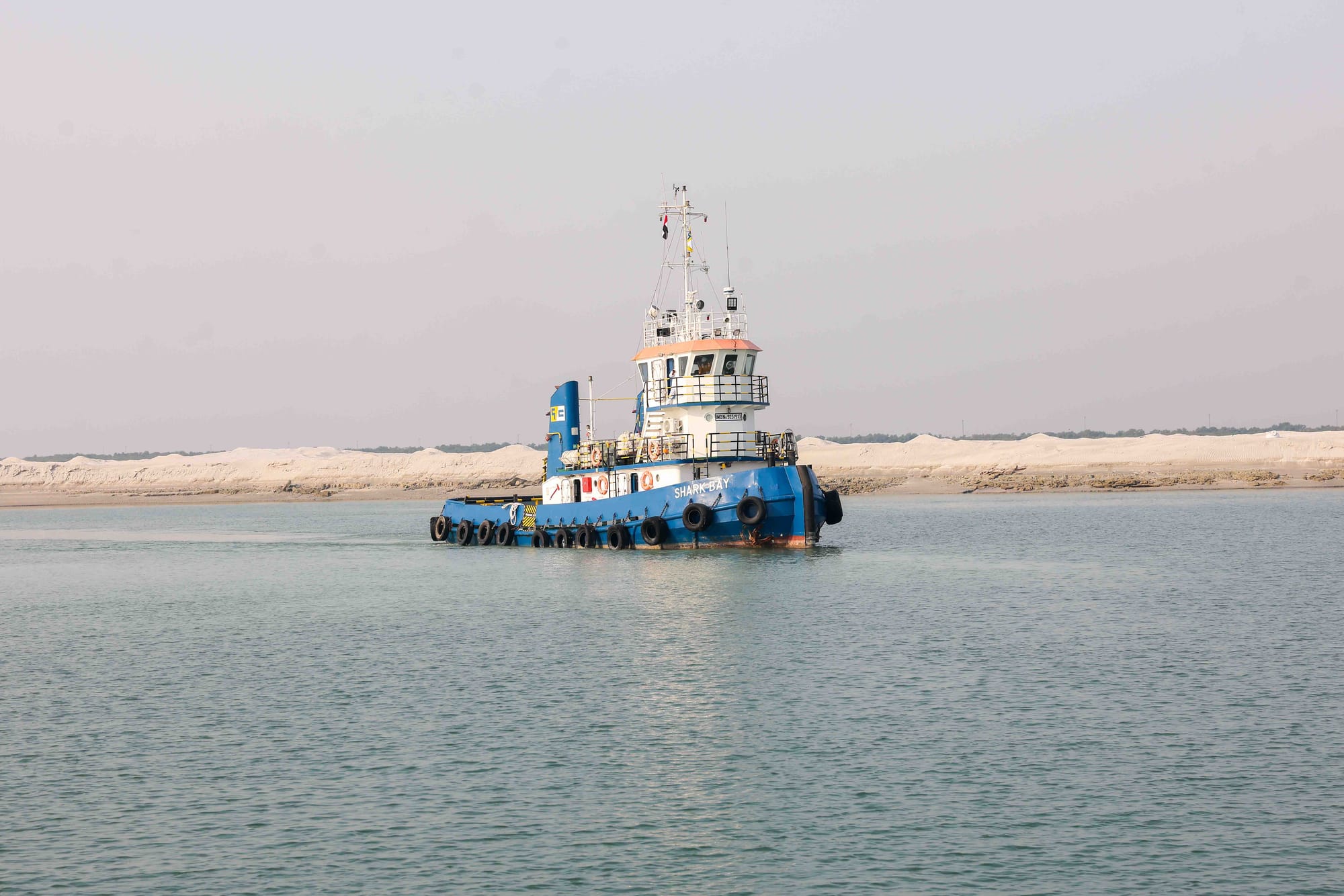 Gulf Cobla workboat Flounder Bay crossing open water with a long arched causeway on the horizon.