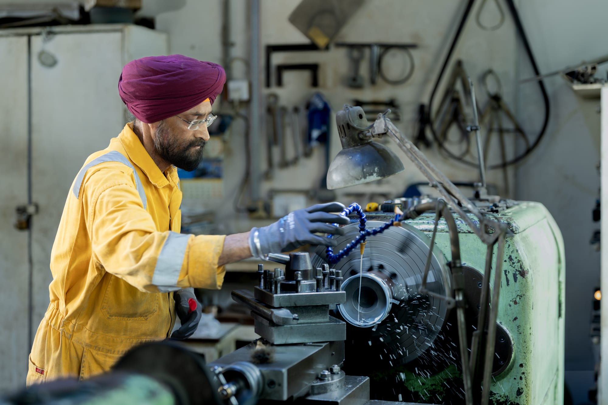 A machinist working at a lathe in the Gulf Cobla workshop.