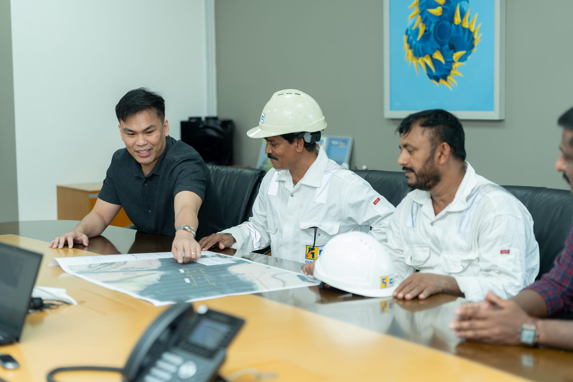 Gulf Cobla staff reviewing project drawings in a meeting.